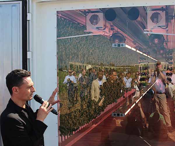 Square Roots co-founder and CEO Tobias Peggs shows attendees the inside of a growing farm, behind a glass panel.