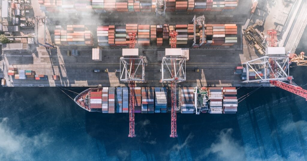 Top view of a cargo ship with containers at a port.