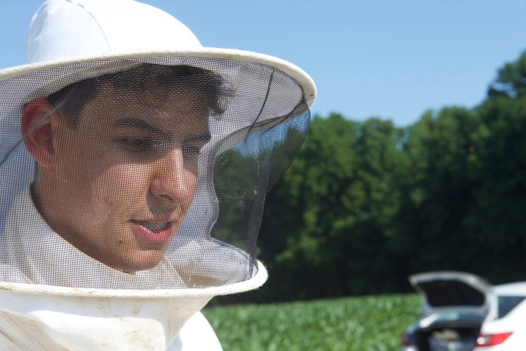 Jacob Pecenka, a graduate student at Purdue University, wears a beekeeper’s hood for his fieldwork. Photo: Purdue University/Tom Campbell