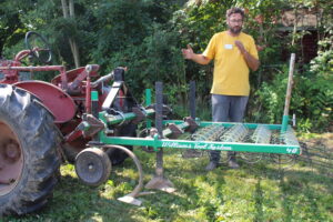photo of man in front of tractor equipment attachment